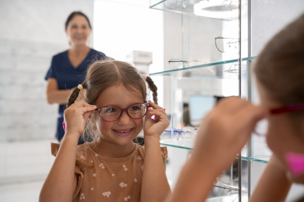 Petite fille souriante avec des lunettes en arrière plan l'opticien
